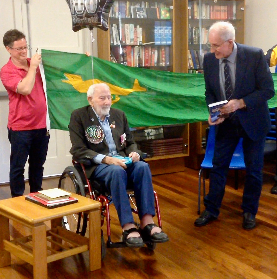 Peter Field and Trevor Luff fly the ANARE Club flag over John Russell